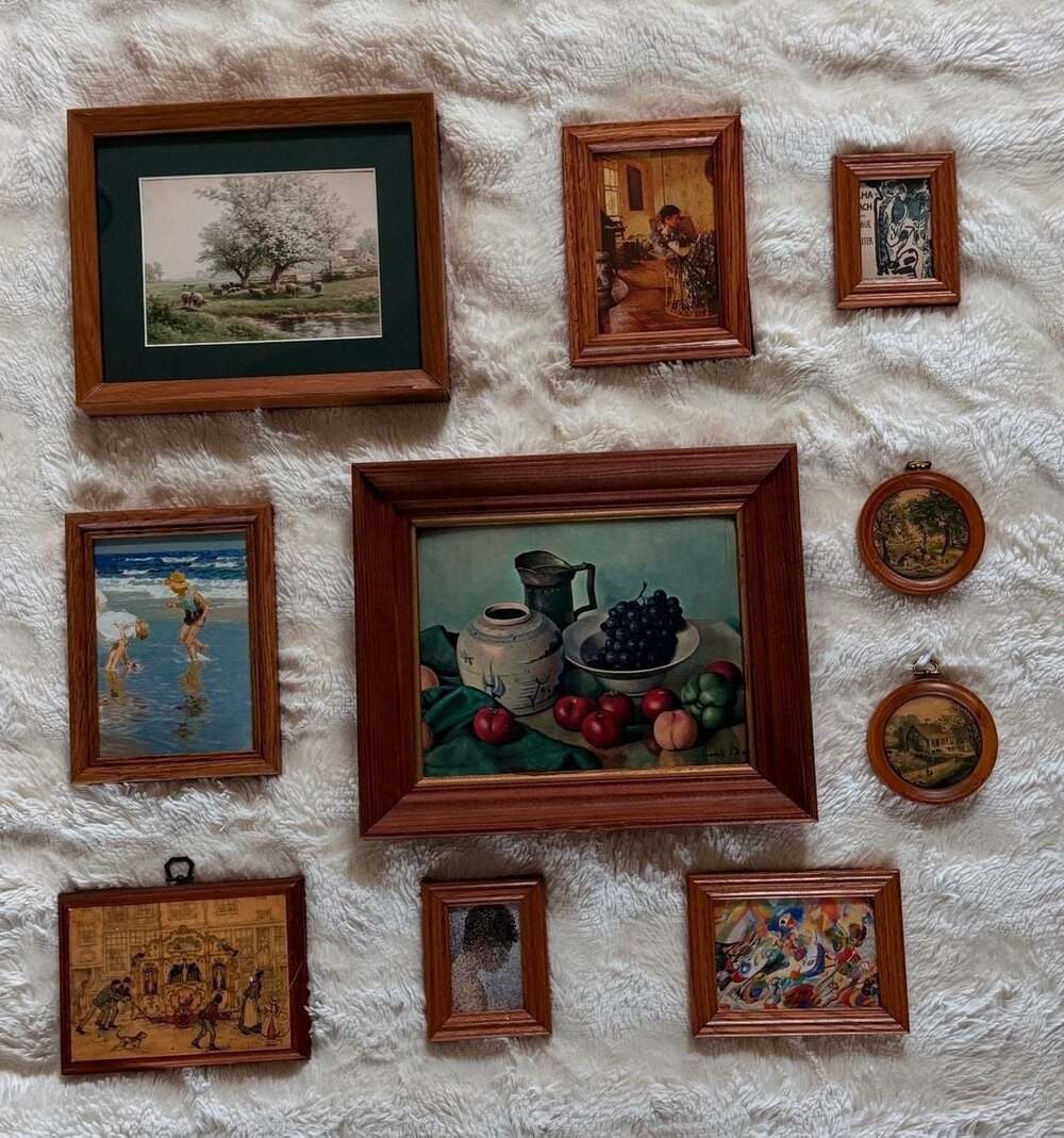 Curated gallery wall with matching oak frames contain famous artists prints
